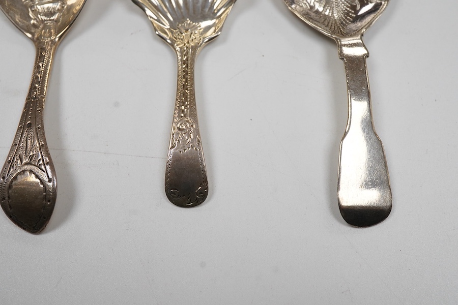 A George IV silver fiddle pattern caddy spoon, the bowl engraved with thistles, James Beebe, London, 1825, 90mm, a Georgian siler caddy spoon, the bowl embossed with urn and flowers, a late Victorian silver caddy spoon w